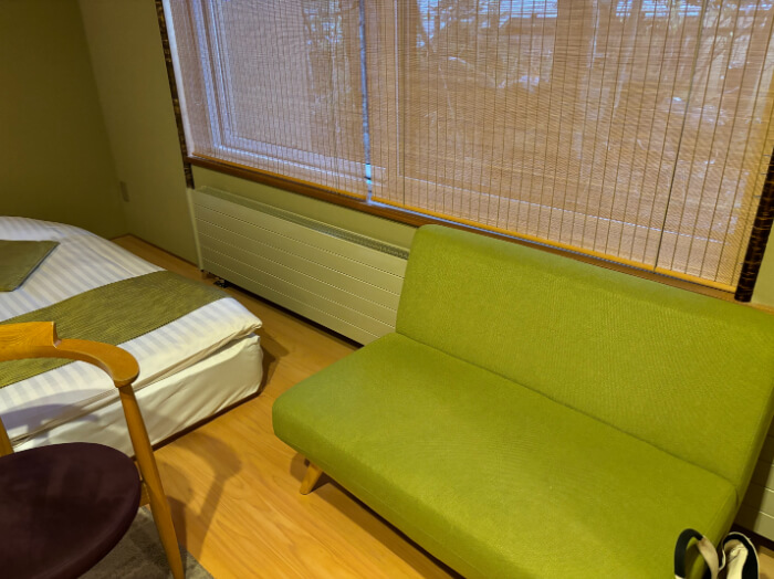 窓際にあるソファ。窓にはすだれがかかっている。