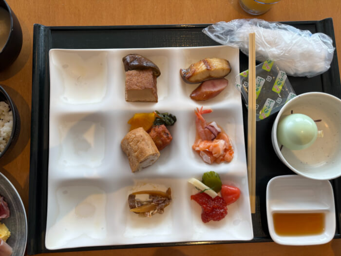 ビュッフェレストランでの朝食。まりも豆腐、めかぶ。取ってきた料理はほっけ、ウィンナー、たらこ、すじこ、甘えび、いなり寿司、漬物、厚揚げの煮物など。