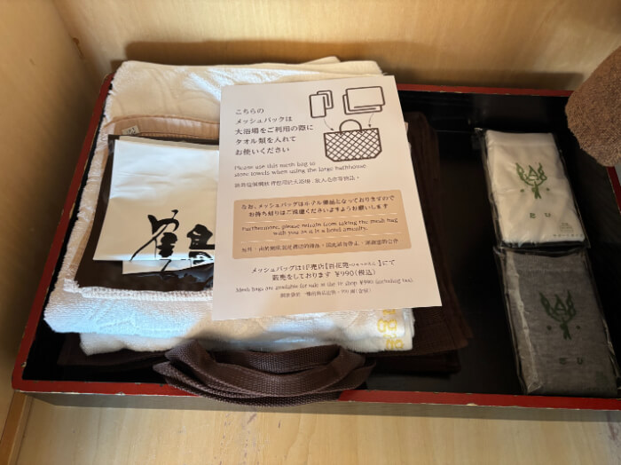 クローゼットの中にバスタオル、ハンドタオル、ビニール袋2種、メッシュバッグが2人分。白とグレーの足袋が1足ずつある。
